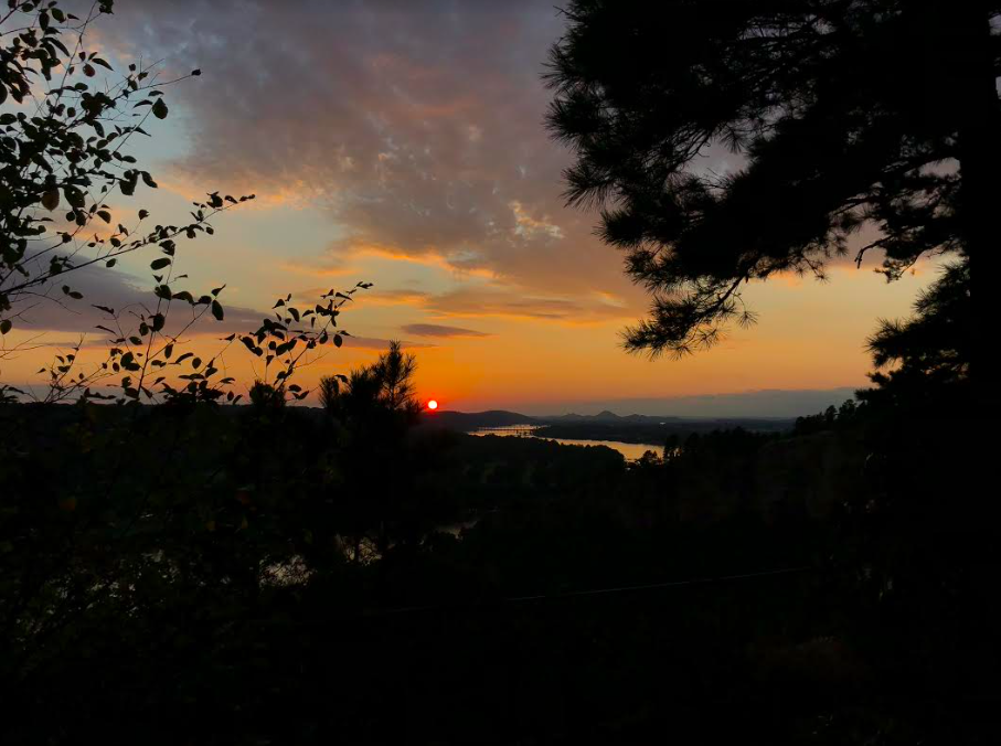 red sun setting over mountains and river